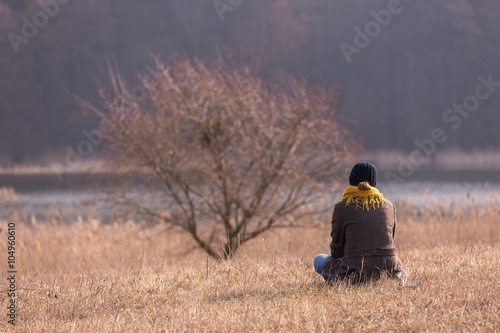 Young woman sitting on grass on meadow © milosz_g
