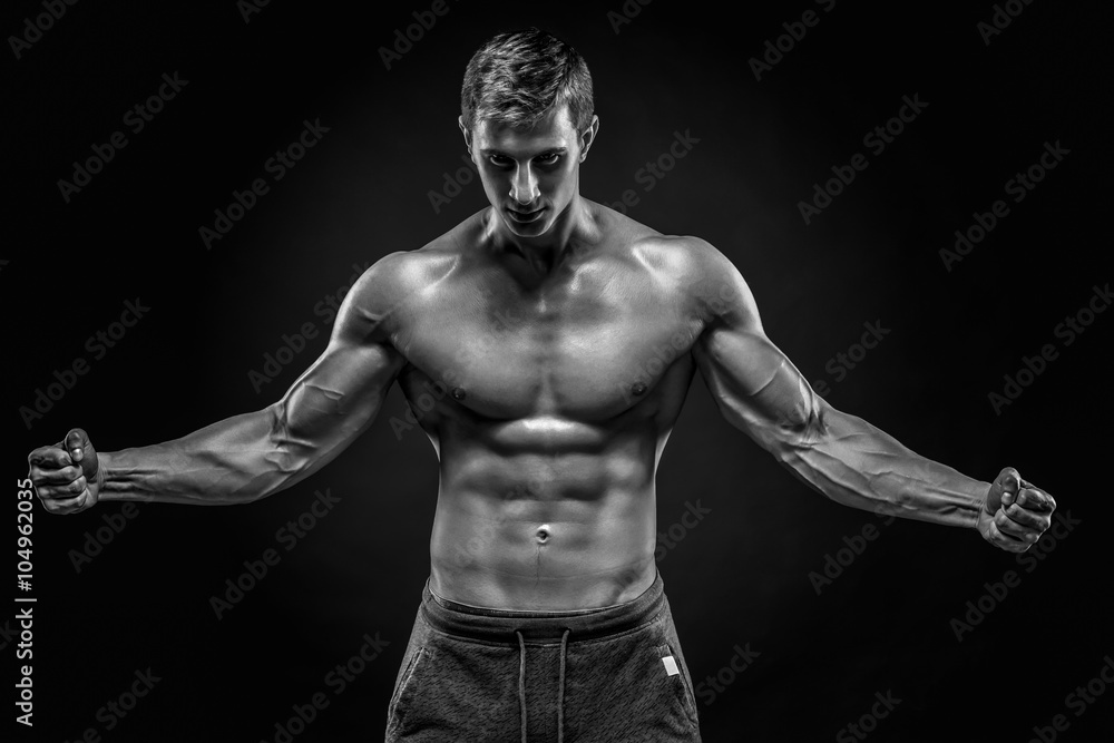 Naklejka premium Stunning muscular man showing perfect abs, shoulders, biceps, tr