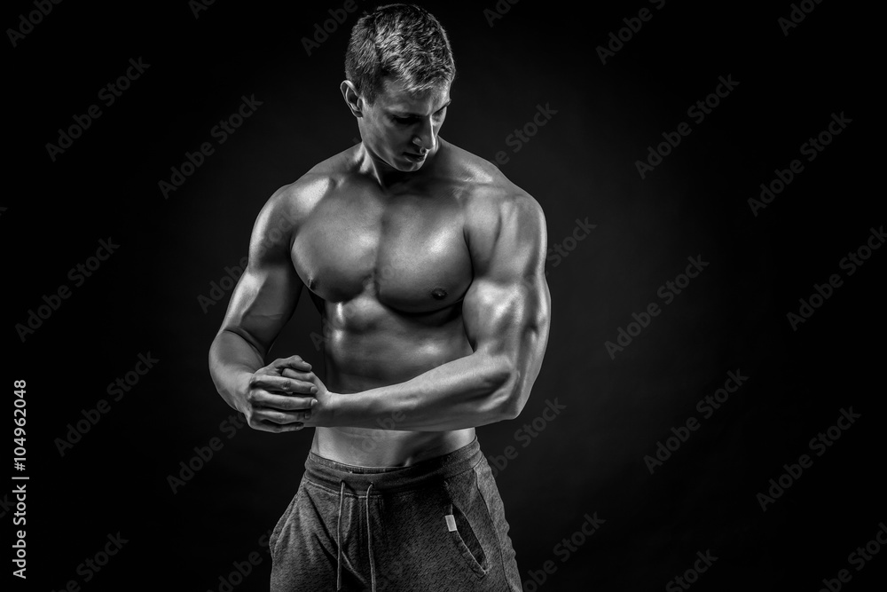 Stunning muscular man showing perfect shoulders, biceps, triceps