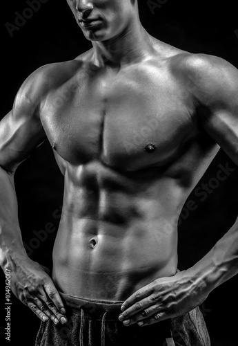 Close-up of a power fitness man on black background