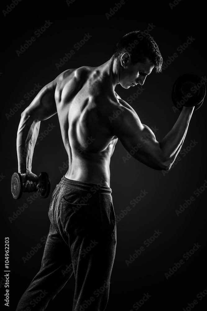 Naklejka premium Fitness man doing exercises with dumbbells at biceps, rear view