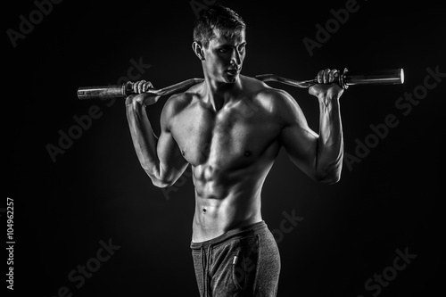 Strong man holding barbell on his shoulders, looking to side © nazarovsergey