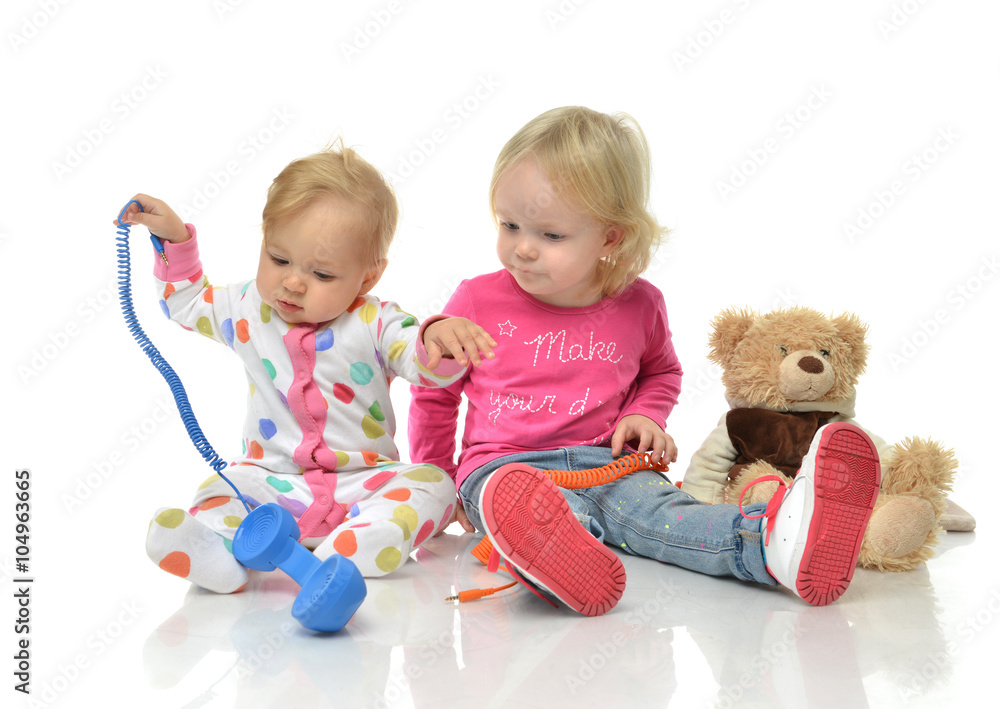 Kids play at home. Children playing with phones Little girl havi Kids play at home. Children playing with phones Little girl havi