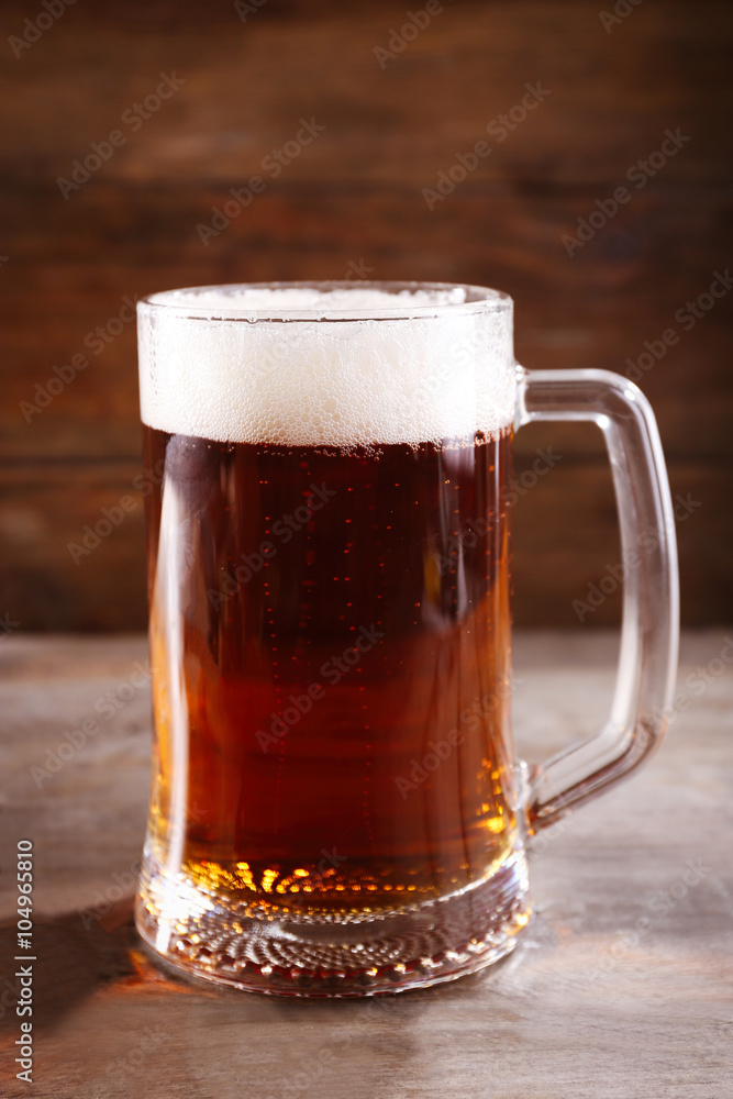 Glass mug of light beer on wooden table, close up Glass mug of light beer on wooden table, close up