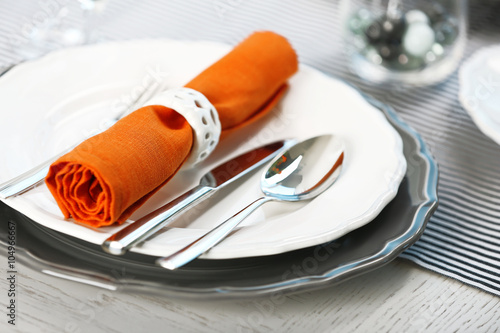 Served table with orange napkin in restaurant, closeup