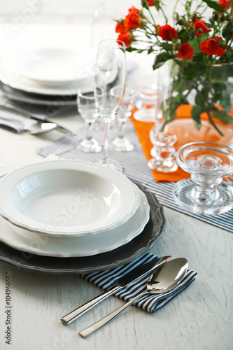 Served table with flowers in restaurant, closeup