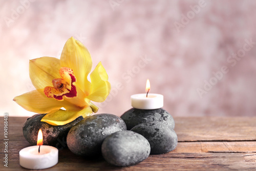 Spa still life with stones  flower and candlelight on blurred pastel background