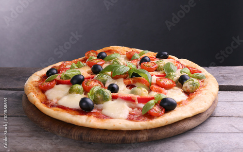 Delicious pizza with cheese and vegetables on grey background