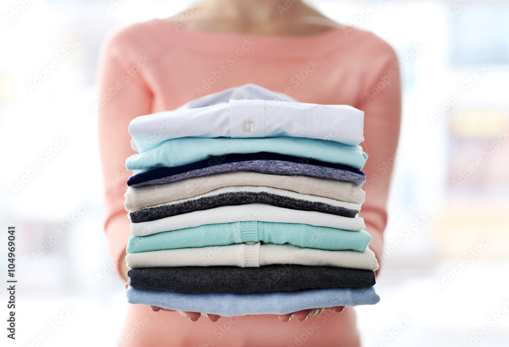 Woman hold clothes pile, close up Woman hold clothes pile, close up