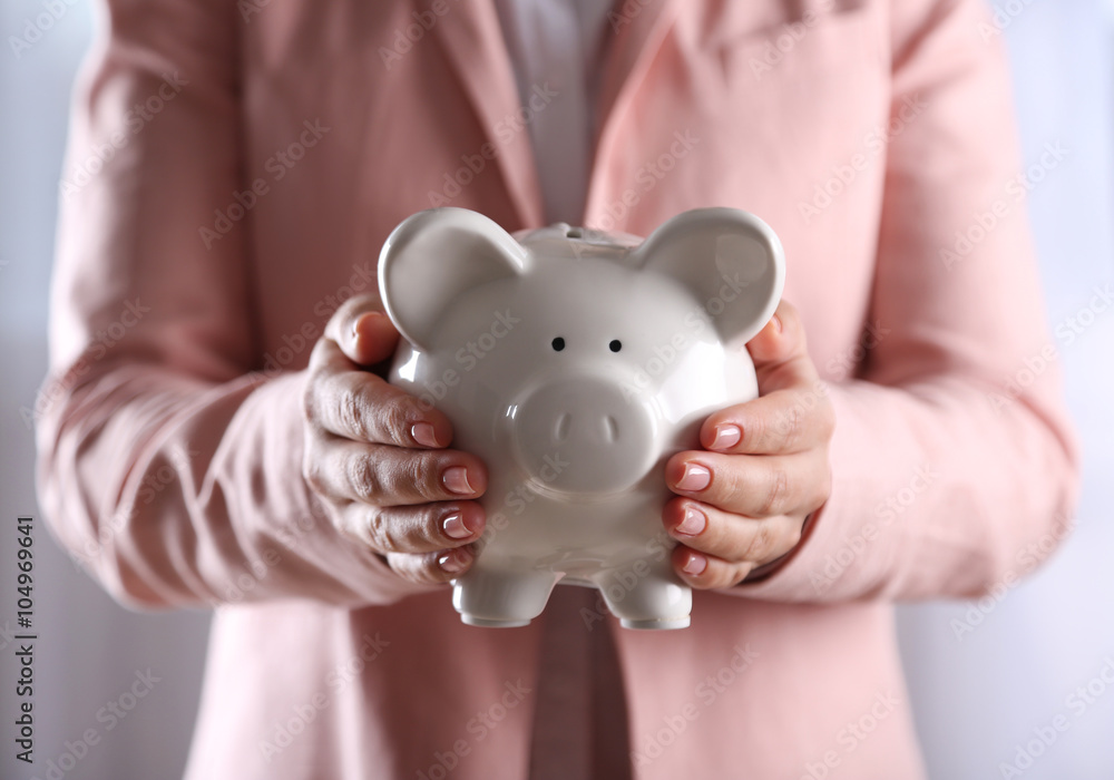 Woman holding in hands piggy bank, close up Woman holding in hands piggy bank, close up