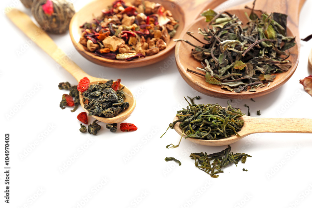 Different sorts of dry tea in wooden spoons, isolated on white Different sorts of dry tea in wooden spoons, isolated on white