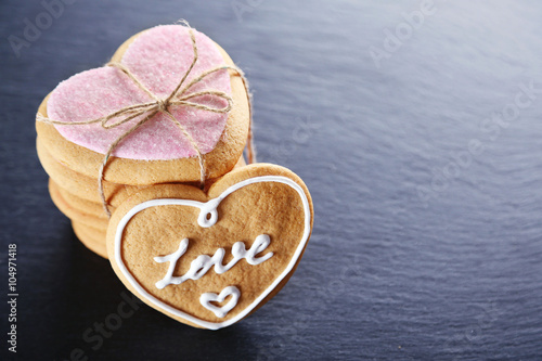 Pink love cookies on dark background, closeup