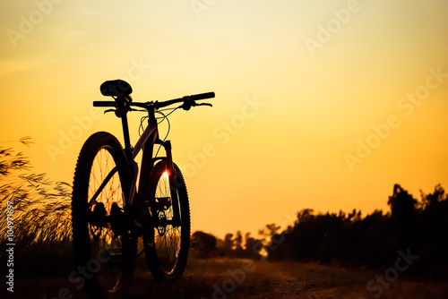 Silhouette of mountain biker in single track on sunset sky