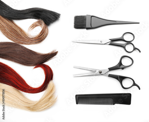 Hairdresser's scissors with tools and varicolored strands of hair, isolated on white