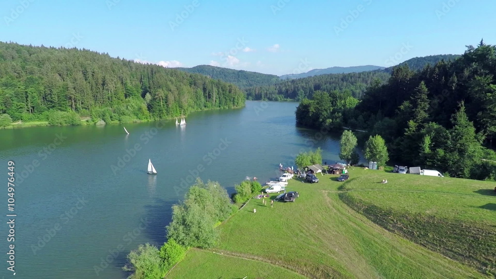 A sailing boat sailing to the bank of the lake A sailing boat sailing to the bank of the lake