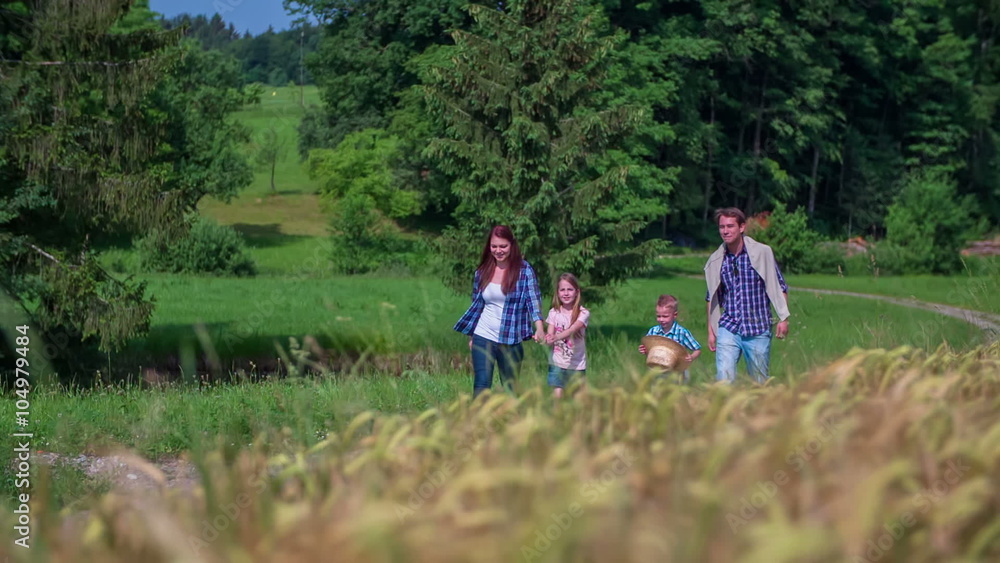 Family is walking on countryside near wheat field Family is walking on countryside near wheat field