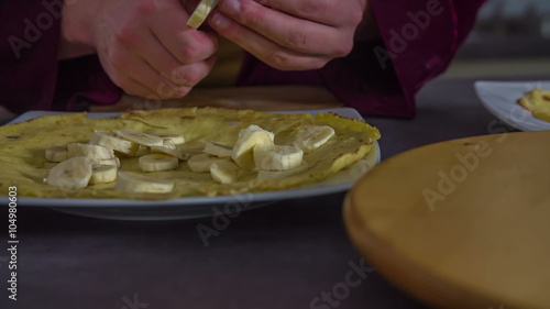 Cutting a banana into small pieces for a pancake photo