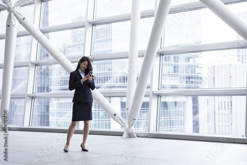 Business women who are using a smart phone in the modern building