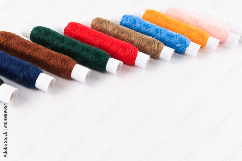 Colorful sewing bobbin thread isolated on white.