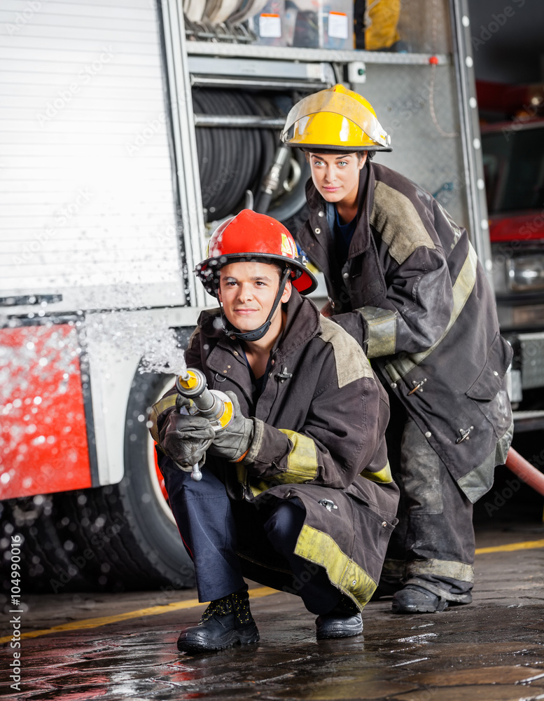Fototapeta premium Confident Firefighters Spraying Water During Practice