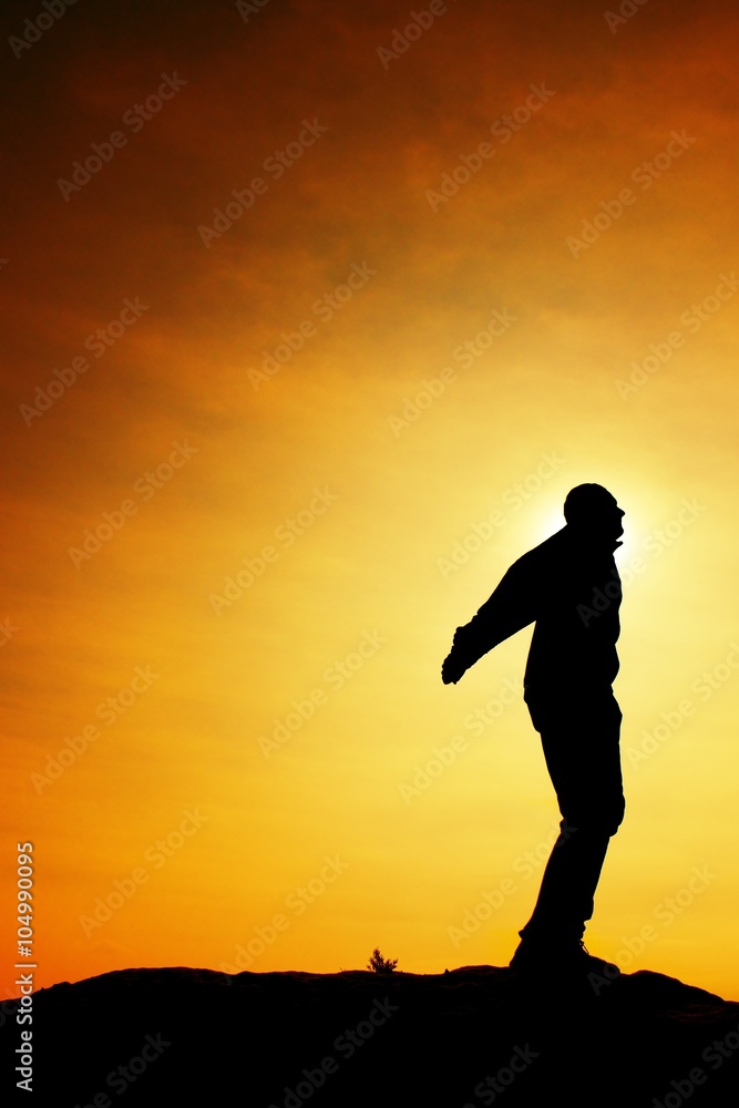 Man ready to jump. Adult crazy man is jumping on colorful sky background.Silhouette of man and beautiful sunset sky.