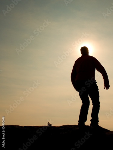 Man ready to jump. Adult crazy man is jumping on colorful sky background.Silhouette of man and beautiful sunset sky