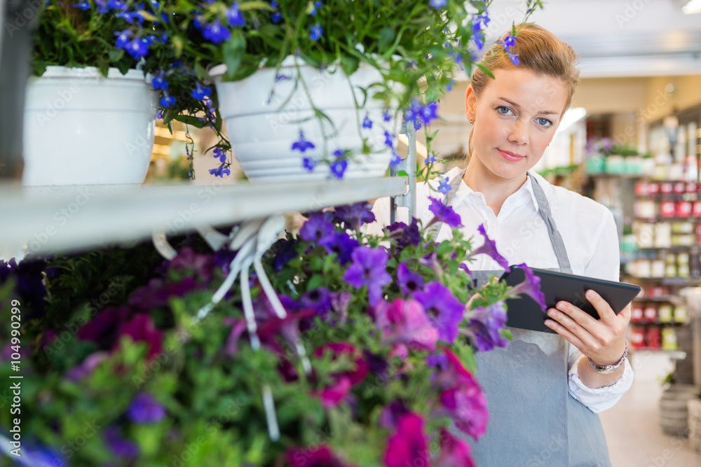 Confident Florist Holding Digital Tablet While Standing By Flowe