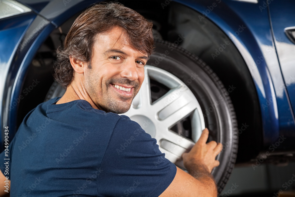 Happy Mechanic Fixing Hubcap To Tire Happy Mechanic Fixing Hubcap To Tire