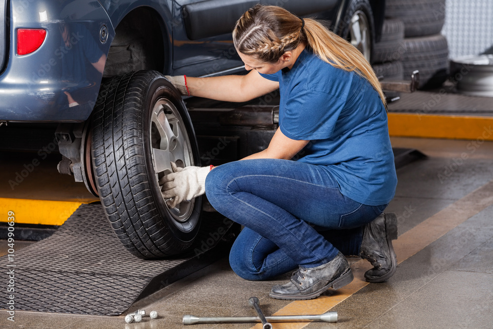 Mechanic Replacing Car Wheel At Repair Shop Mechanic Replacing Car Wheel At Repair Shop