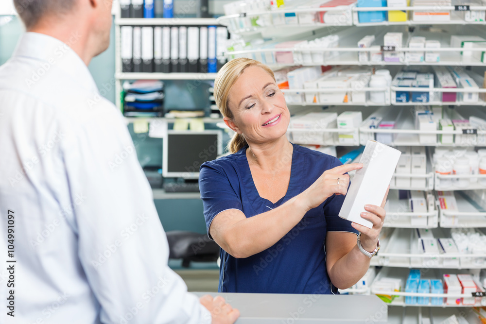Pharmacist Showing Details Of Product To Customer In Pharmacy Pharmacist Showing Details Of Product To Customer In Pharmacy