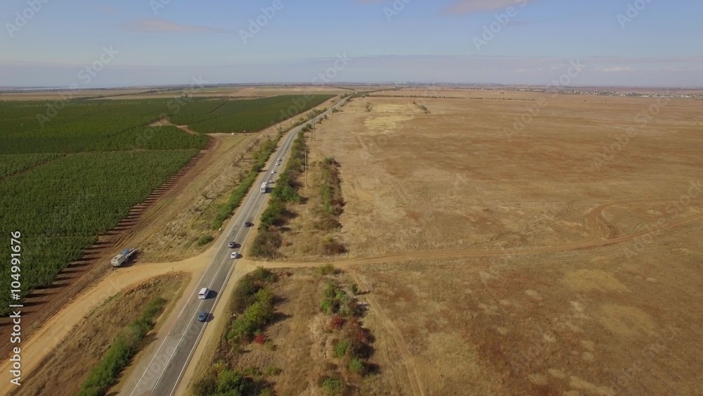 Moving Cars On Country Road Between Garden And Field Moving Cars On Country Road Between Garden And Field