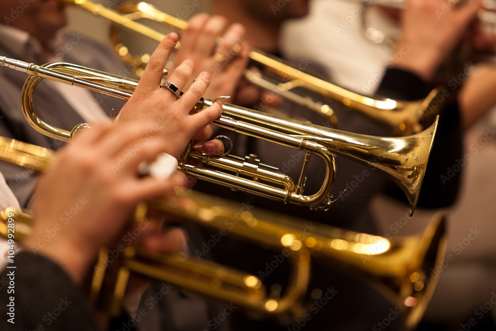 Obraz premium Trąbki w rękach muzyka w zbliżeniu orkiestry