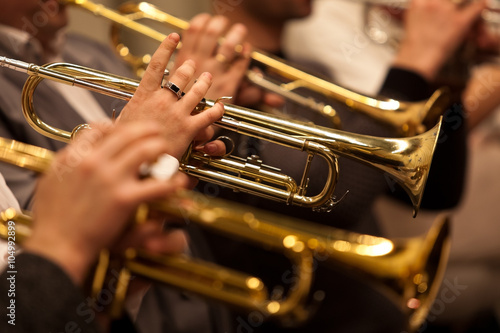 Trumpets in the hands of a musician in the orchestra closeup