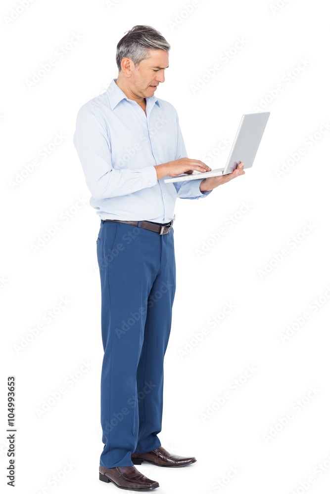 Smiling businessman typing on laptop Smiling businessman typing on laptop