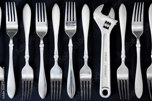 Set of forks, and wrench on a black background
