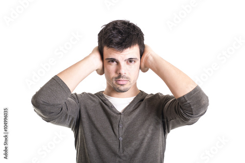Young man covering his ears with hands on a white background