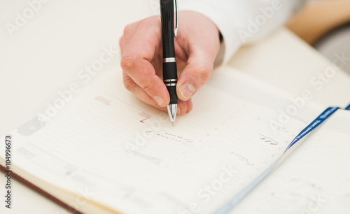 businessman writes in a notebook