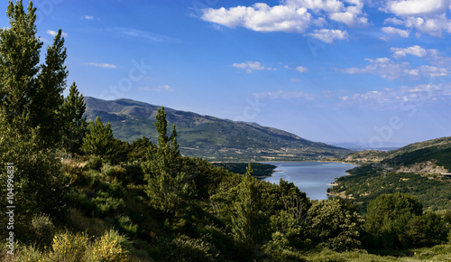 Mountain landscape with a lake and some towns and a road, in Cáceres, Spain