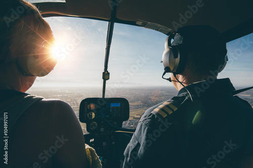 Two pilots in a helicopter while flying on a sunny day