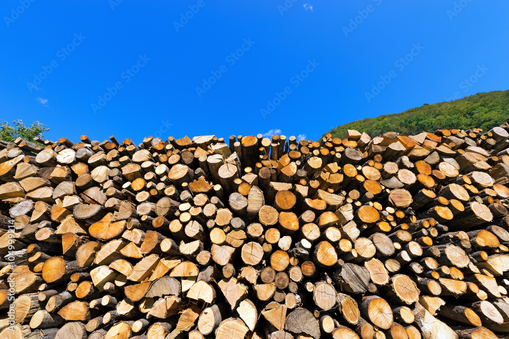 Pile of Chopped Firewood on Blue Sky / Dry chopped firewood logs in a pile on blue sky prepared for winter