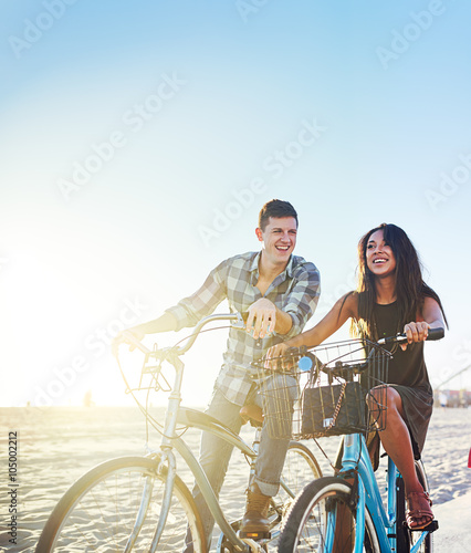 couple on bicycles stopped at sunny california beach