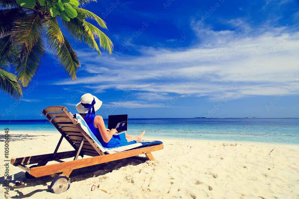 Fototapeta premium young woman with laptop on tropical beach