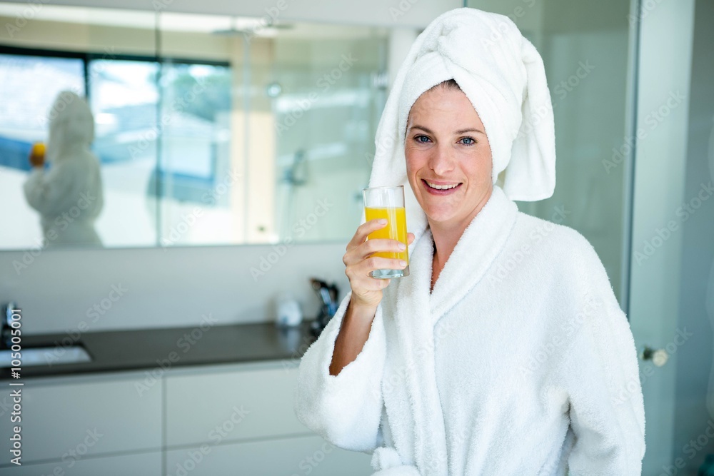 woman wearing a dressing gown drinking a glass of juice woman wearing a dressing gown drinking a glass of juice