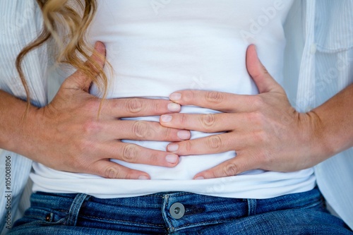 woman clutching her stomach in discomfort