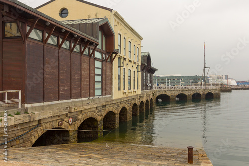 Old arches of stone at the port of Gijon, Spain