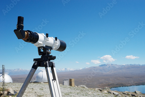 telescope and observatory on ground near lake in summer day in new zealand