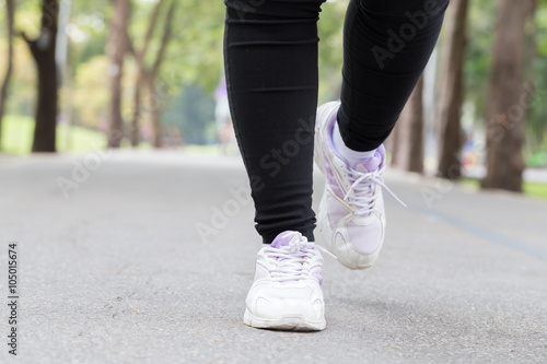 Closeup of leg of woman jogging in park