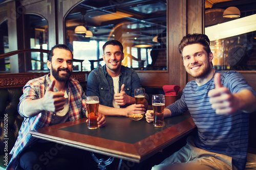Sticker happy male friends drinking beer at bar or pub