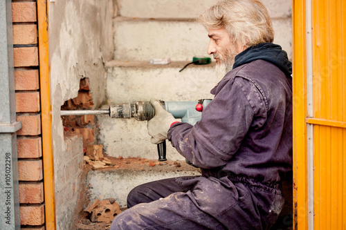 Принти на полотні Builder worker with pneumatic hammer drill equipment breaking br