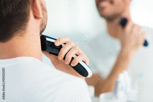 close up of man shaving beard with trimmer